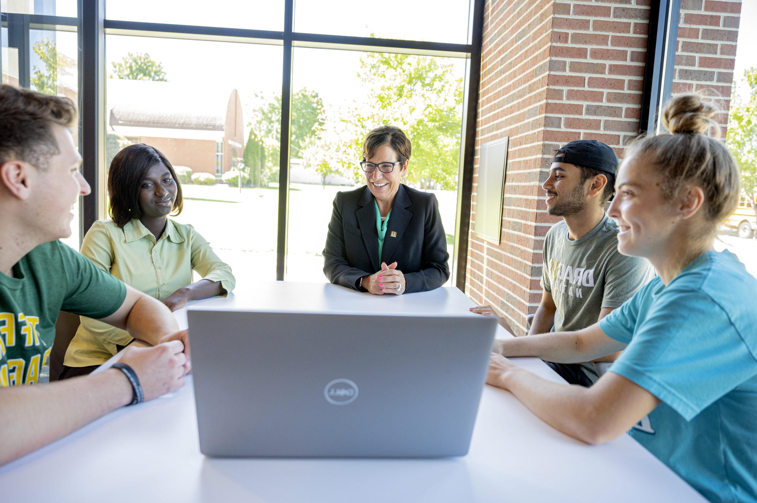 University president with a group of smiling students